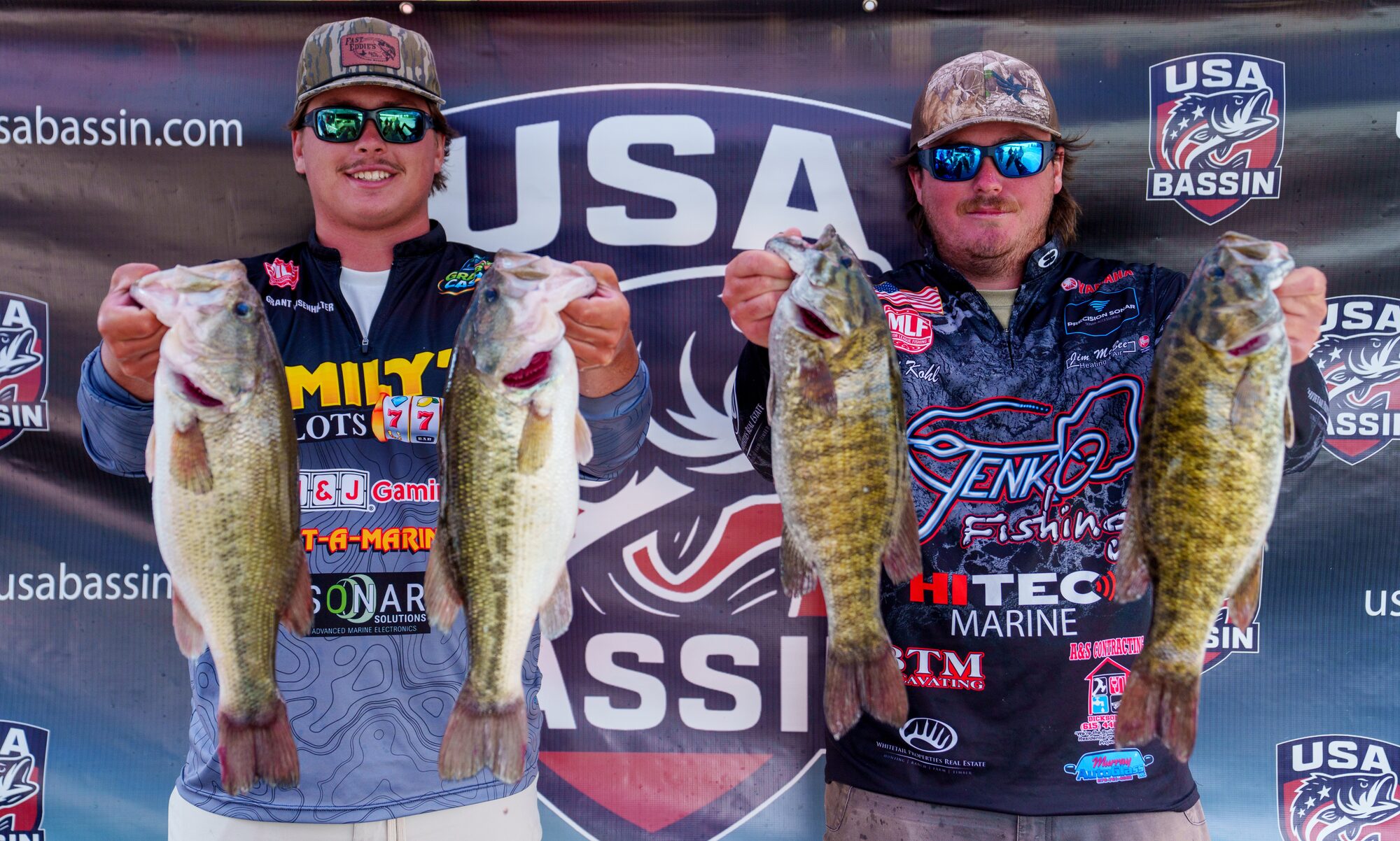 USA BASSIN anglers holding bass at the championship stage backdrop